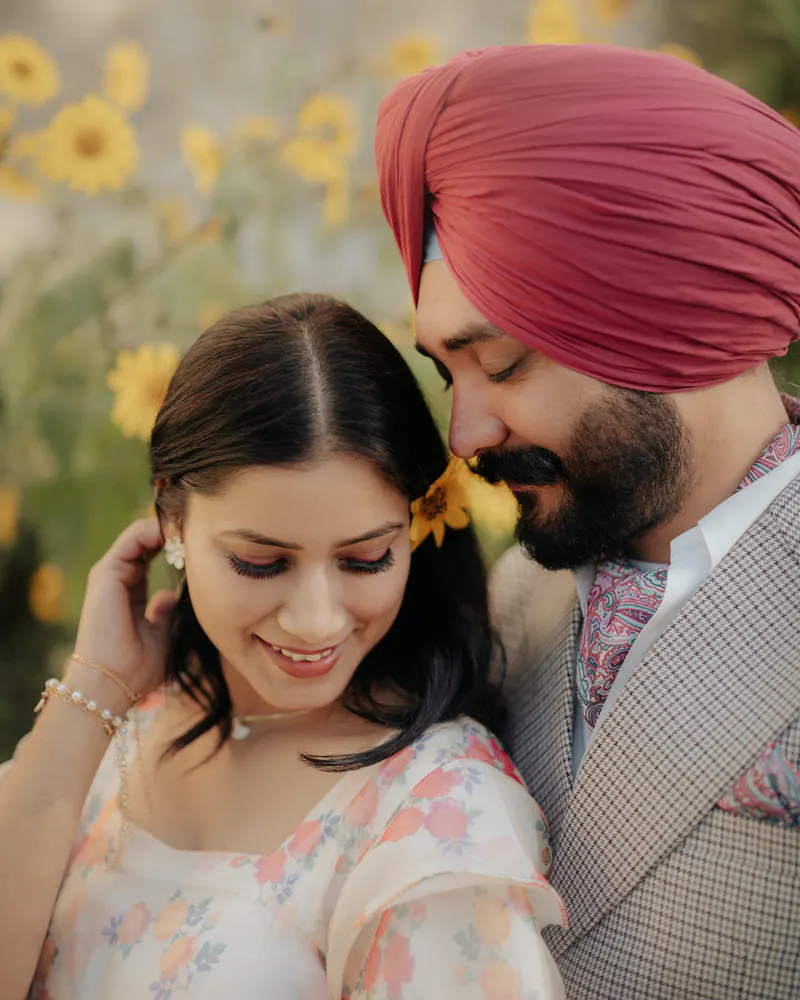 Close-up of a smiling bride with her groom in a pink turban