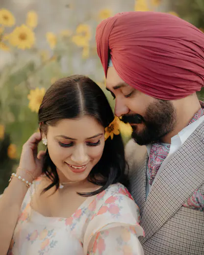 Close-up of a smiling bride with her groom in a pink turban