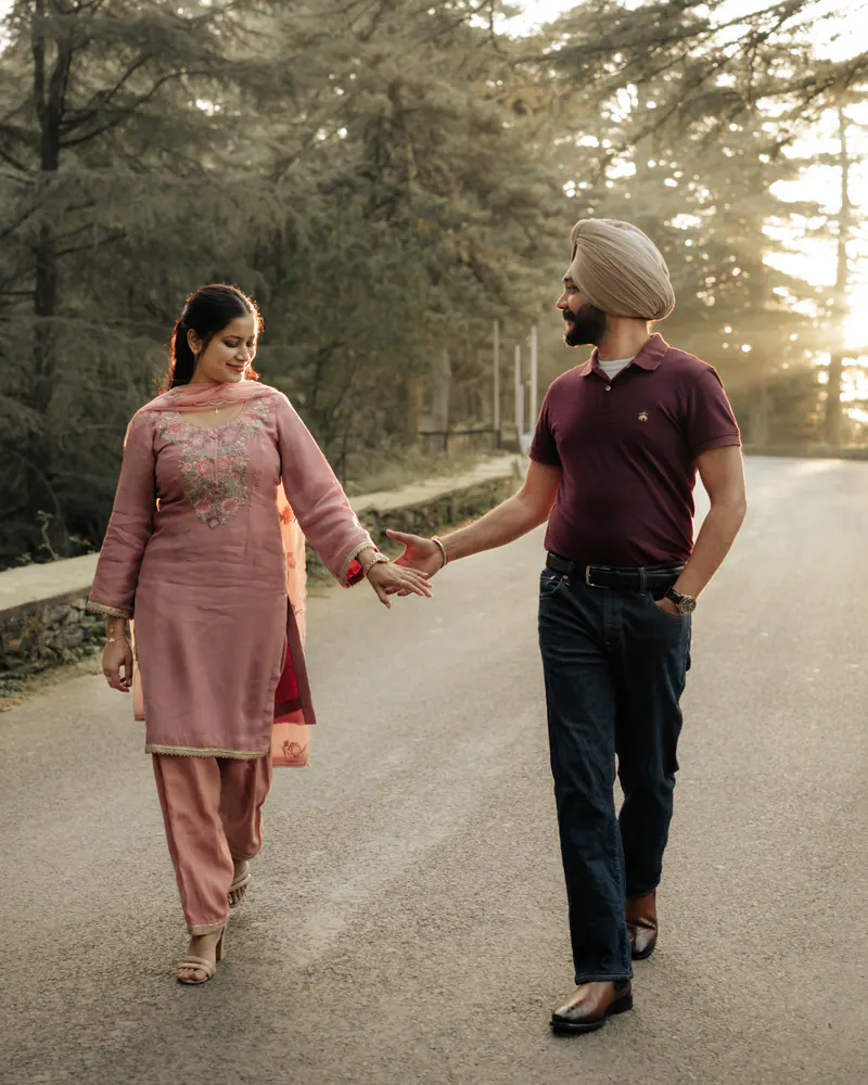 Couple walking hand in hand on a pine-lined road in the hills